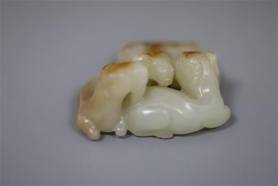 A Chinese pale celadon and russet jade group of three goats, 19th/20th century, 5cm, wood stand
